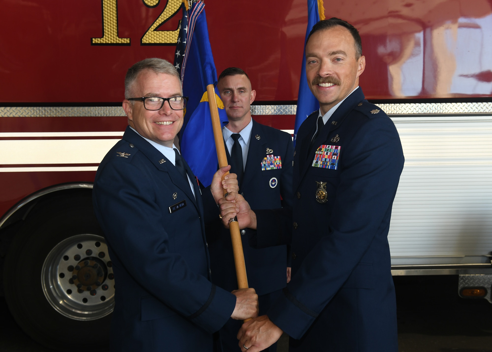 Lt. Col. John LeGloahec, right, accepts command of the 341st Civil Engineer Squadron from Col. Ciro de la Vega III, 341st Mission Support Group commander, left, during a change of command ceremony at Malmstrom Air Force Base, Mont., July 11, 2025.