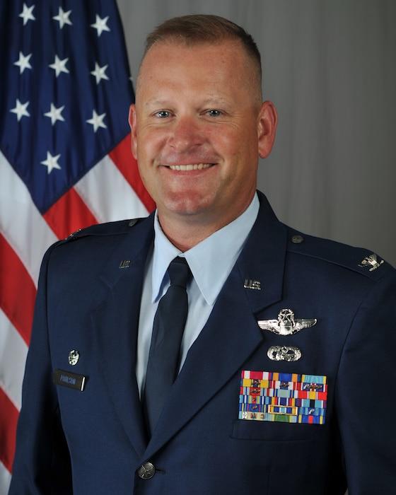 Col. William Poulson, 185th Operations Group Commander, poses for a photo in front of an American flag