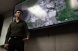 Wolf Russo, Common Operating Picture manager for the Alaska National Guard demonstrates the capabilities of Maven, an AI logistics software system, at the Joint Operations Center in the AKNG Armory on Joint Base-Elmendorf Richardson, July 11, 2025 Maven fuses data from multiple sources to enhance the COP and uses AI tools to track logistics, personnel and resource movements while recommending courses of action based on real-time input.  (Alaska National Guard photo by Seth LaCount)