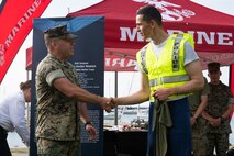 U.S. Marine Corps Lt Col. Eric Perez, an operations and plans officer assigned to Special Purpose Marine Air-Ground Task Force-250, awards Strahinja Calasan, a Chicago Police Department recruit, with a 250th Marine Corps birthday shirt for his high performance during a physical training session at DuSable Harbor during Marine Week Chicago, July 10, 2025. Throughout the year, Marines across the globe will celebrate the 250th birthday of the Corps, commemorating service, sacrifice, and priding themselves on living ‘Semper Fidelis’ or ‘Always Faithful’ to their nation and to each other. (U.S. Marine Corps photo by Lance Cpl. Andra Marton-Salgado)