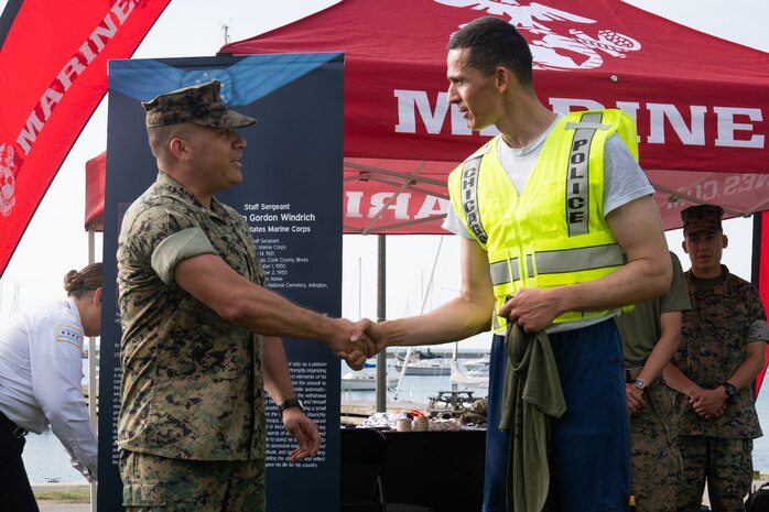 U.S. Marine Corps Lt Col. Eric Perez, an operations and plans officer assigned to Special Purpose Marine Air-Ground Task Force-250, awards Strahinja Calasan, a Chicago Police Department recruit, with a 250th Marine Corps birthday shirt for his high performance during a physical training session at DuSable Harbor during Marine Week Chicago, July 10, 2025. Throughout the year, Marines across the globe will celebrate the 250th birthday of the Corps, commemorating service, sacrifice, and priding themselves on living ‘Semper Fidelis’ or ‘Always Faithful’ to their nation and to each other. (U.S. Marine Corps photo by Lance Cpl. Andra Marton-Salgado)
