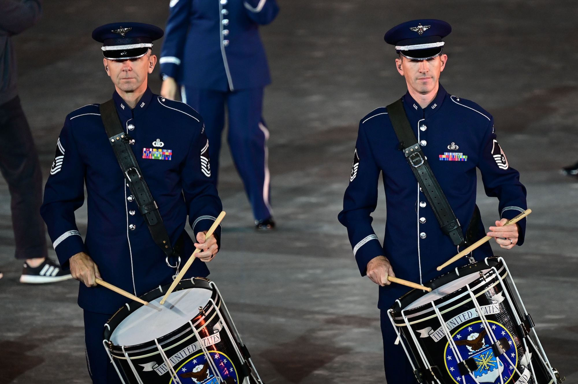 photo of two U.S. Air Force Band members playing the drums while marching