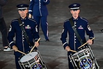 photo of two U.S. Air Force Band members playing the drums while marching