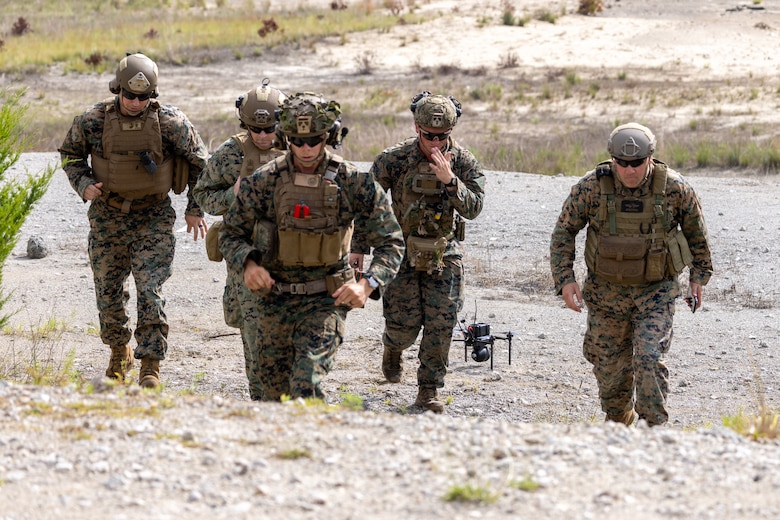 U.S. Marines with Advanced Infantry Training Battalion, School of Infantry – East run up range after preparing a Neros Archer small unmanned aircraft system (SUAS) for flight during a combined live-arms training event involving the employment of SUAS to deliver munitions on designated targets at Camp Lejeune, North Carolina, July 3, 2025. This event marked the first time munitions were employed from SUAS during a live-fire training exercise on Camp Lejeune, demonstrating the capability of integrating aerial strike capabilities at the tactical level. (U.S. Marine Corps photo by Cpl. Zachariah Ferraro)