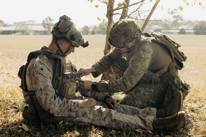 Australian Army Private Denver Jamieson, right, a medical operator with 1st Health Battalion, applies simulated combat gauze to U.S. Marine Corps Cpl. Hansen Dean, a motorman with 2nd Battalion, 1st Marine Regiment, Marine Rotational Force – Darwin 25.3 during tactical combat casualty care training at Robertson Barracks, Darwin, Australia, June 25, 2025.