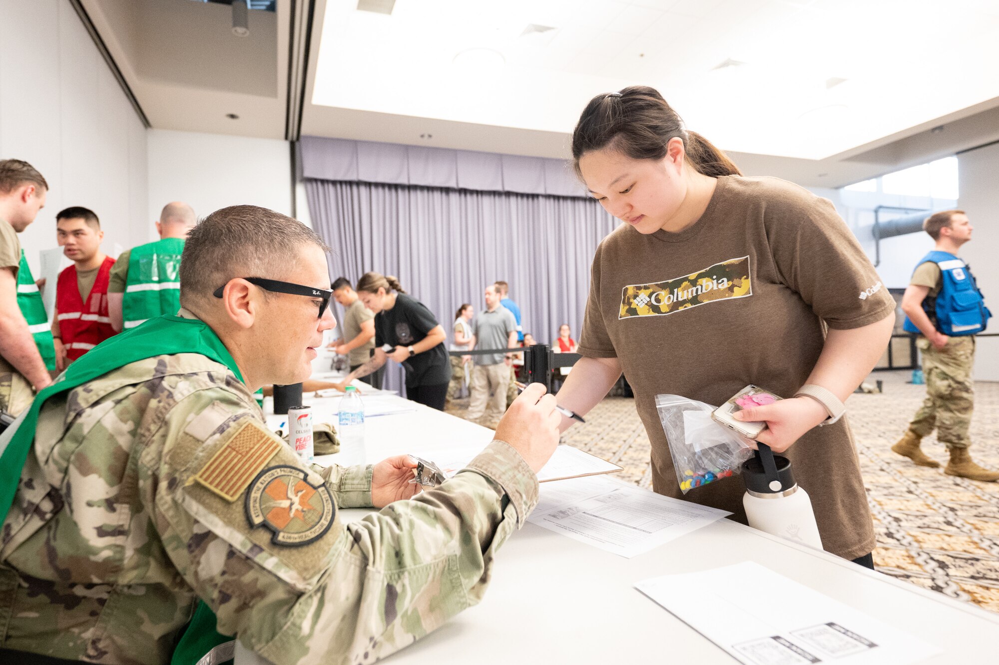 U.S. Air Force Master Sgt. Matthew Amiot, 436th Healthcare Operations Squadron pharmacy flight chief, dispenses simulated medication to a patient during a biohazard disaster response exercise conducted by the 436th Medical Group at Dover Air Force Base, Delaware, June 9, 2025. The exercise challenged medical staff on how to triage and treat personnel after being exposed to simulated Anthrax. (U.S. Air Force photo by Mauricio Campino)