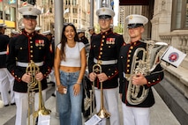 U.S. Marines with the Quantico Marine Band, assigned to Special Purpose Marine Air-Ground Task Force-250, and a Chicago resident pose for a photo during Marine Week Chicago, July 10, 2025. The opening ceremony signifies the start of Marine Week Chicago and represents the ethos of U.S. Marines to city residents. Throughout 2025, Marines across the globe will celebrate the 250th birthday of the Corps, commemorating service, sacrifice, and priding themselves on living ‘Semper Fidelis’ or ‘Always Faithful’ to their nation and to each other. (U.S. Marine Corps photo by Lance Cpl. Elijua Guel)