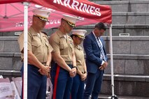 U.S. Marine Corps Col. J.J. Wilson, the commanding officer of Special Purpose Marine Air-Ground Task Force-250, left, U.S. Marine Corps Lt. Col. Dan Lakhani, the inspector-instructor for 2nd Battalion, 24th Marine Regiment, second to the left, U.S. Marine Corps Lt. Col. Justine Davie, the Communication Strategy and Operations director for Marine Week Chicago, second to the right, all assigned to Special Purpose Marine Air-Ground Task Force-250, and Jassen Strokosch, the chief of staff for the Illinois Department of Veteran Affairs, bow their heads during a prayer for a wreath laying ceremony at the Vietnam Veterans Memorial during Marine Week Chicago, July 11, 2025. The wreath laying ceremony was held to honor U.S. Marine Corps Sgt. Thomas Gilbert and other Marines who paid the ultimate sacrifice during Operation Iraqi Freedom. This year, the Marine Corps will celebrate two and a half centuries of serving the nation with honor, courage, and commitment. (U.S. Marine Corps photo by Lance Cpl. Elijua Guel)