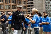 U.S. Marine Corps Capt. James Mercure, the deputy Communication Strategy and Operations Officer of Marine Week Chicago, assigned to Special Purpose Marine Air-Ground Task Force-250, interacts with the Make-A-Wish staff during a ceremony for Jamaria Peters at the Willis Tower for Marine Week Chicago, July 11, 2025. The event featured a performance from the Marine Corps Silent Drill Platoon, music from the Quantico Marine Band, and the appearance of drill instructors from Marine Corps Recruit Depot San Diego. This year, the Marine Corps will celebrate two and a half centuries of serving the nation with honor, courage, and commitment. (U.S. Marine Corps photo by Lance Cpl. Elijua Guel)