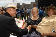 U.S. Marine Corps Col. J.J. Wilson, the commanding officer of Special Purpose Marine Air-Ground Task Force-250, gives a certificate of appreciation to Jamaria Peters, a Make-A-Wish recipient, during a ceremony for Peters at the Willis Tower for Marine Week Chicago, July 11, 2025. The event featured a performance from the Marine Corps Silent Drill Platoon, music from the Quantico Marine Band, and the appearance of drill instructors from Marine Corps Recruit Depot San Diego. This year, the Marine Corps will celebrate two and a half centuries of serving the nation with honor, courage, and commitment. (U.S. Marine Corps photo by Lance Cpl. Elijua Guel)