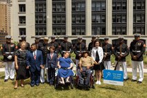 The U.S. Marine Corps Silent Drill Platoon, assigned to Special Purpose Marine Air-Ground Task Force-250, Jamaria Peters, a Make-A-Wish recipient, and other Make-A-Wish recipients with several family members, pose for a photo during a ceremony for Jamaria Peters at the Willis Tower during Marine Week Chicago, July 11, 2025. The event featured a performance from the Marine Corps Silent Drill Platoon, music from the Quantico Marine Band, and the appearance of drill instructors from Marine Corps Recruit Depot San Diego. This year, the Marine Corps will celebrate two and a half centuries of serving the nation with honor, courage, and commitment. (U.S. Marine Corps photo by Lance Cpl. Elijua Guel)