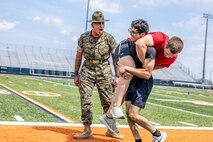 U.S. Marine Corps Sgt. Rasheed Awyan, a drill instructor with Marine Corps Recruit Depot San Diego, 2nd Recruit Training Battalion, motivates a poolee during a combat fitness test at Romeoville High School during Marine Week Chicago, July 10, 2025. During Marine Week Chicago, Marines with Marine Corps Recruiting Command shared Marine Corps traditions with local high schools in honor of the Corps’ 250th birthday. The Marine Corps is celebrating its 250th birthday with six multi-day Marine Corps community events, called Marine Weeks, in six major cities across the country. Marine Weeks will include activations across each host city featuring aircraft, equipment, recruiting opportunities, and public engagements. (U.S. Marine Corps Staff Sgt. Brandon Salas)