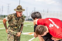 U.S. Marine Corps Sgt. Rasheed Awyan, a drill instructor with Marine Corps Recruit Depot San Diego, 2nd Recruit Training Battalion, motivates a poolee during a combat fitness test at Romeoville High School during Marine Week Chicago, July 10, 2025. During Marine Week Chicago, Marines with Marine Corps Recruiting Command shared Marine Corps traditions with local high schools in honor of the Corps’ 250th birthday. The Marine Corps is celebrating its 250th birthday with six multi-day Marine Corps community events, called Marine Weeks, in six major cities across the country. Marine Weeks will include activations across each host city featuring aircraft, equipment, recruiting opportunities, and public engagements. (U.S. Marine Corps Staff Sgt. Brandon Salas)
