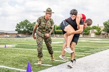 U.S. Marine Corps Sgt. Rasheed Awyan, a drill instructor with Marine Corps Recruit Depot San Diego, 2nd Recruit Training Battalion, motivates a poolee during a combat fitness test at Romeoville High School during Marine Week Chicago, July 10, 2025. During Marine Week Chicago, Marines with Marine Corps Recruiting Command shared Marine Corps traditions with local high schools in honor of the Corps’ 250th birthday. The Marine Corps is celebrating its 250th birthday with six multi-day Marine Corps community events, called Marine Weeks, in six major cities across the country. Marine Weeks will include activations across each host city featuring aircraft, equipment, recruiting opportunities, and public engagements. (U.S. Marine Corps Staff Sgt. Brandon Salas)