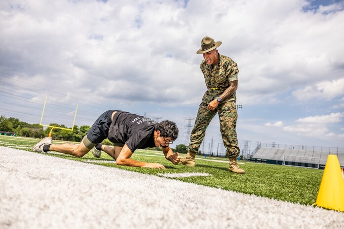 U.S. Marine Corps Sgt. Rasheed Awyan, a drill instructor with Marine Corps Recruit Depot San Diego, 2nd Recruit Training Battalion, motivates a poolee during a combat fitness test at Romeoville High School during Marine Week Chicago, July 10, 2025. During Marine Week Chicago, Marines with Marine Corps Recruiting Command shared Marine Corps traditions with local high schools in honor of the Corps’ 250th birthday. The Marine Corps is celebrating its 250th birthday with six multi-day Marine Corps community events, called Marine Weeks, in six major cities across the country. Marine Weeks will include activations across each host city featuring aircraft, equipment, recruiting opportunities, and public engagements. (U.S. Marine Corps Staff Sgt. Brandon Salas)