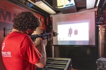 A poolee with Recruiting Station Chicago shoots at targets inside the Indoor Simulated Marksmanship Trainer in the interior of the Marine Corps Enhanced Marketing Vehicle semi-truck at Romeoville High School during Marine Week Chicago, Illinois, July 10, 2025. During Marine Week Chicago, Marines with Marine Corps Recruiting Command shared Marine Corps traditions with local high schools in honor of the Corps’ 250th birthday. The Marine Corps is celebrating its 250th birthday with six multi-day Marine Corps community events, called Marine Weeks, in six major cities across the country. Marine Weeks will include activations across each host city featuring aircraft, equipment, recruiting opportunities, and public engagements. (U.S. Marine Corps photo by Staff Sgt. Brandon Salas)