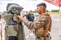 U.S. Marine Corps SSgt. Jalen Riddle, an explosive ordnance disposal (EOD) technician with 8th Engineer Support Battalion, shows a member of the community an EOD suit at Romeoville High School during Marine Week Chicago, July 10, 2025. During Marine Week Chicago, Marines with Marine Corps Recruiting Command shared Marine Corps traditions with local high schools in honor of the Corps’ 250th birthday. The Marine Corps is celebrating its 250th birthday with six multi-day Marine Corps community events, called Marine Weeks, in six major cities across the country. Marine Weeks will include activations across each host city featuring aircraft, equipment, recruiting opportunities, and public engagements. (U.S. Marine Corps photo by Staff Sgt. Brandon Salas)
