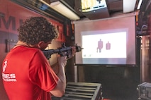 A poolee with Recruiting Station Chicago shoots at targets inside the Indoor Simulated Marksmanship Trainer in the interior of the Marine Corps Enhanced Marketing Vehicle semi-truck at Romeoville High School during Marine Week Chicago, Illinois, July 10, 2025. During Marine Week Chicago, Marines with Marine Corps Recruiting Command shared Marine Corps traditions with local high schools in honor of the Corps’ 250th birthday. The Marine Corps is celebrating its 250th birthday with six multi-day Marine Corps community events, called Marine Weeks, in six major cities across the country. Marine Weeks will include activations across each host city featuring aircraft, equipment, recruiting opportunities, and public engagements. (U.S. Marine Corps photo by Staff Sgt. Brandon Salas)