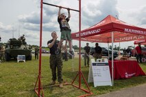A U.S. Marine with Recruiting Station Nashville, assists a young attendee from the Cracker Barrel 400 brand activation during Marine Week Nashville 2025 at the Nashville Superspeedway, Nashville, Tennessee, June 1, 2025. Founded on November 10, 1775, the United States Marine Corps has served our nation honorably in every clime and place for 250 years. Throughout 2025, Marines across the globe will celebrate the 250th birthday of the Corps, commemorating service, sacrifice, and priding themselves on living 'Semper Fidelis' or 'Always Faithful' to their nation and to each other. (U.S. Marine Corps photo by Lance Cpl. Judith Ann Lazaro)