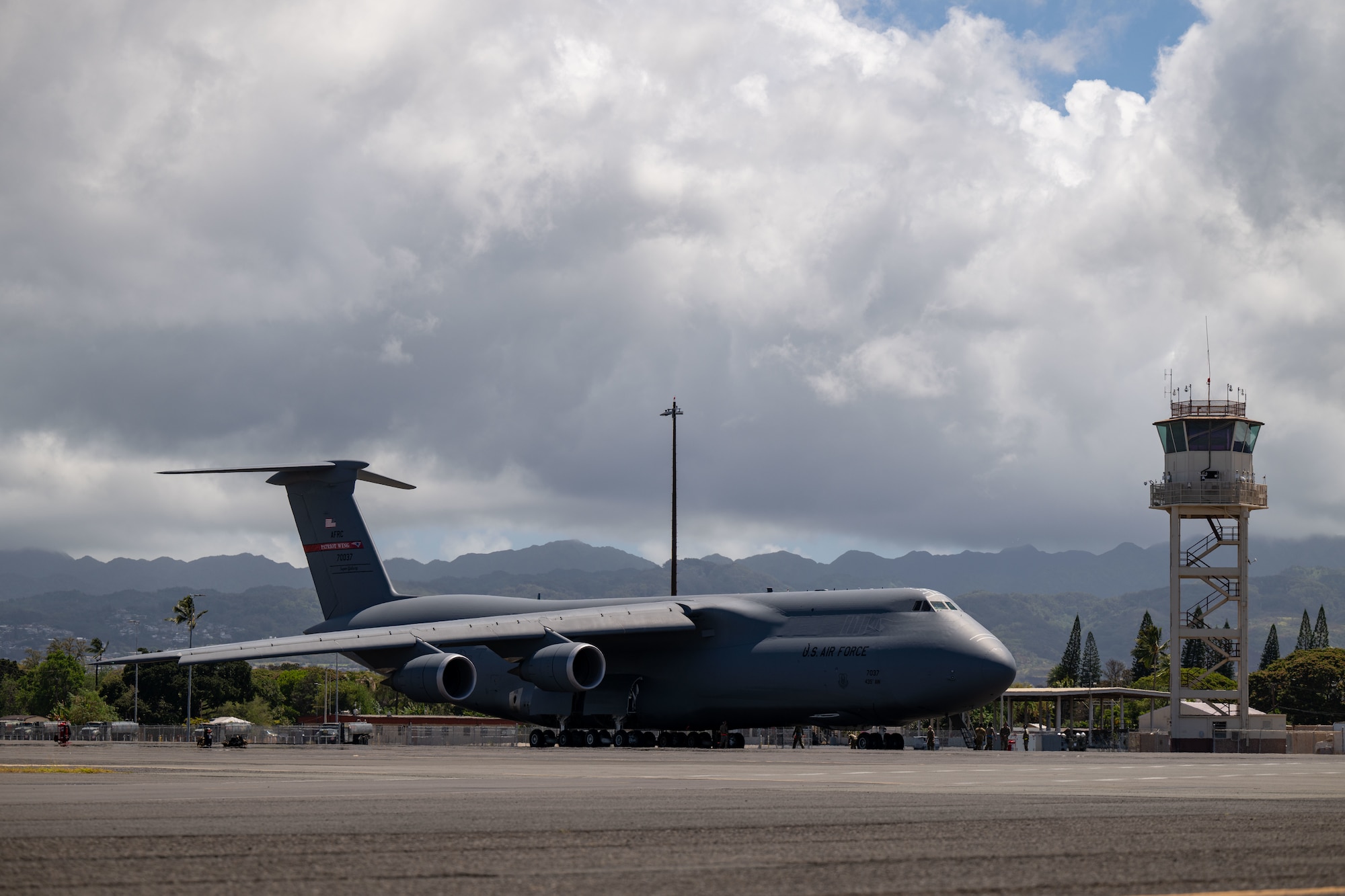 A C-5M Super Galaxy aircraft assigned to the 439th Airlift Wing parks on the flight line in support of the Air Force’s 2025 Department-Level Exercise series at Joint Base Pearl Harbor-Hickam, Hawai’i, July 10, 2025. This exercise proves the Air Force’s ability to maneuver the Joint Force into any theater of operation to meet global requirements. This mission is part of the first-in-a-generation DLE series, a new way of conducting operations in a contested, dynamic environment to build capabilities making a stronger, more lethal deterrent force. The DLE series encompasses all branches of the Department of Defense, along with Allies and partners, employing more than 400 Joint and coalition aircraft and more than 12,000 members at more than 50 locations across 3,000 miles. (U.S. Air Force photo by Tech. Sgt. Monica Roybal)