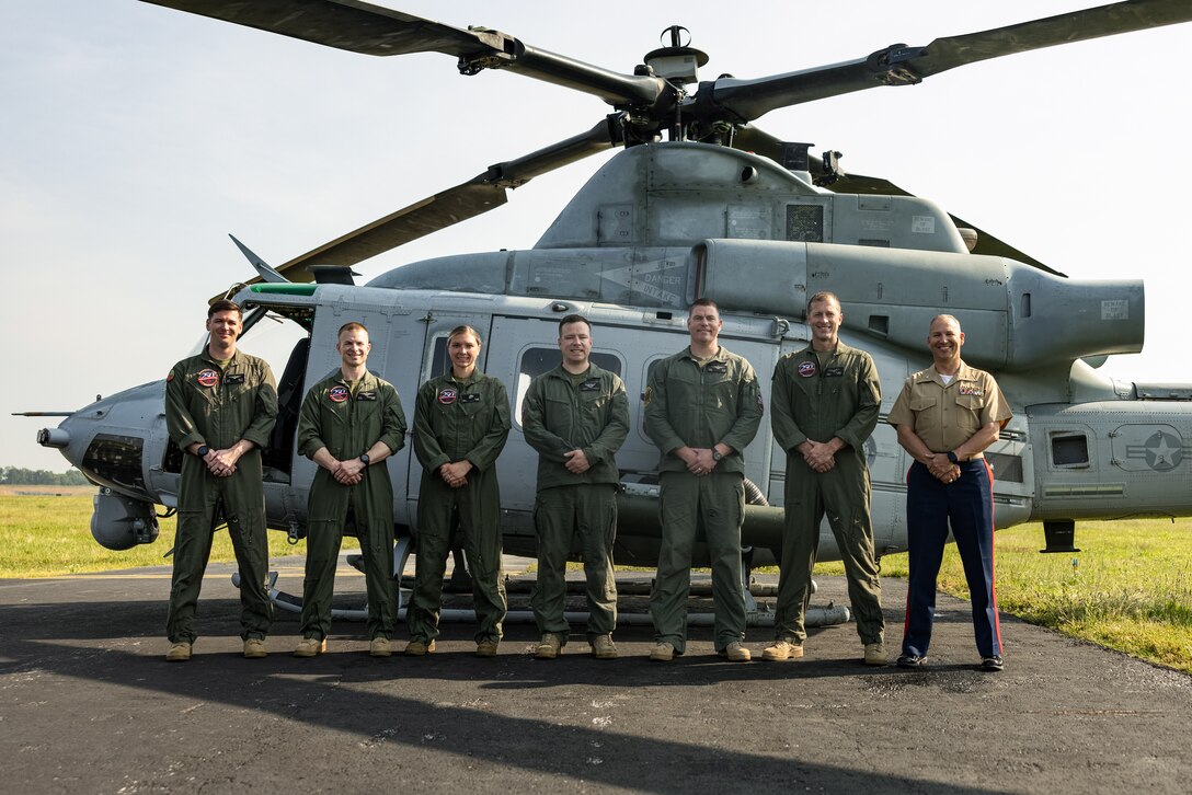 U.S. Marines with Marine Light Attack Helicopter Squadron-773 take a group photo during an Orientation and Indoctrination Flight as part of Marine Week Nashville at John C. Tune Airport, Nashville, Tennessee, June 3, 2025. The O&I flights allowed an opportunity for community leaders around Nashville to see and experience Marine Corps aviation and interact with the Marines maintaining and flying these aircraft. Throughout 2025, Marines across the globe will celebrate the 250th birthday of the Corps, commemorating service, sacrifice, and priding themselves on living 'Semper Fidelis' or 'Always Faithful' to their nation and to each other. (U.S. Marine Corps photo by Lance Cpl. Judith Ann Lazaro)