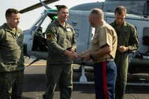 U.S. Marine Corps Col. J.J. Wilson, commanding officer of Special-Purpose Marine Air-Ground Task Force 250, hands a velcro patch to Marines with Marine Light Attack Helicopter Squadron-773 during an Orientation and Indoctrination Flight as part of Marine Week Nashville at John C. Tune Airport, Nashville, Tennessee, June 3, 2025. The O&I flights allowed an opportunity for community leaders around Nashville to see and experience Marine Corps aviation and interact with the Marines maintaining and flying these aircraft. Throughout 2025, Marines across the globe will celebrate the 250th birthday of the Corps, commemorating service, sacrifice, and priding themselves on living 'Semper Fidelis' or 'Always Faithful' to their nation and to each other. (U.S. Marine Corps photo by Lance Cpl. Judith Ann Lazaro)