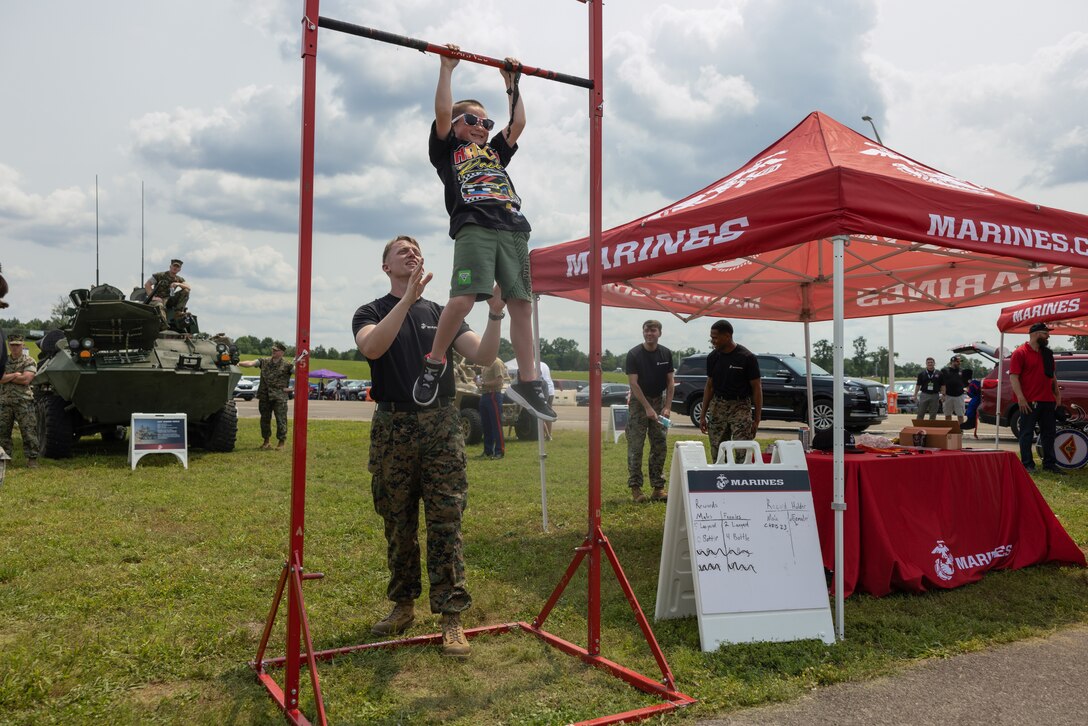 A U.S. Marine with Recruiting Station Nashville, assists a young attendee from the Cracker Barrel 400 brand activation during Marine Week Nashville 2025 at the Nashville Superspeedway, Nashville, Tennessee, June 1, 2025. Founded on November 10, 1775, the United States Marine Corps has served our nation honorably in every clime and place for 250 years. Throughout 2025, Marines across the globe will celebrate the 250th birthday of the Corps, commemorating service, sacrifice, and priding themselves on living 'Semper Fidelis' or 'Always Faithful' to their nation and to each other. (U.S. Marine Corps photo by Lance Cpl. Judith Ann Lazaro)