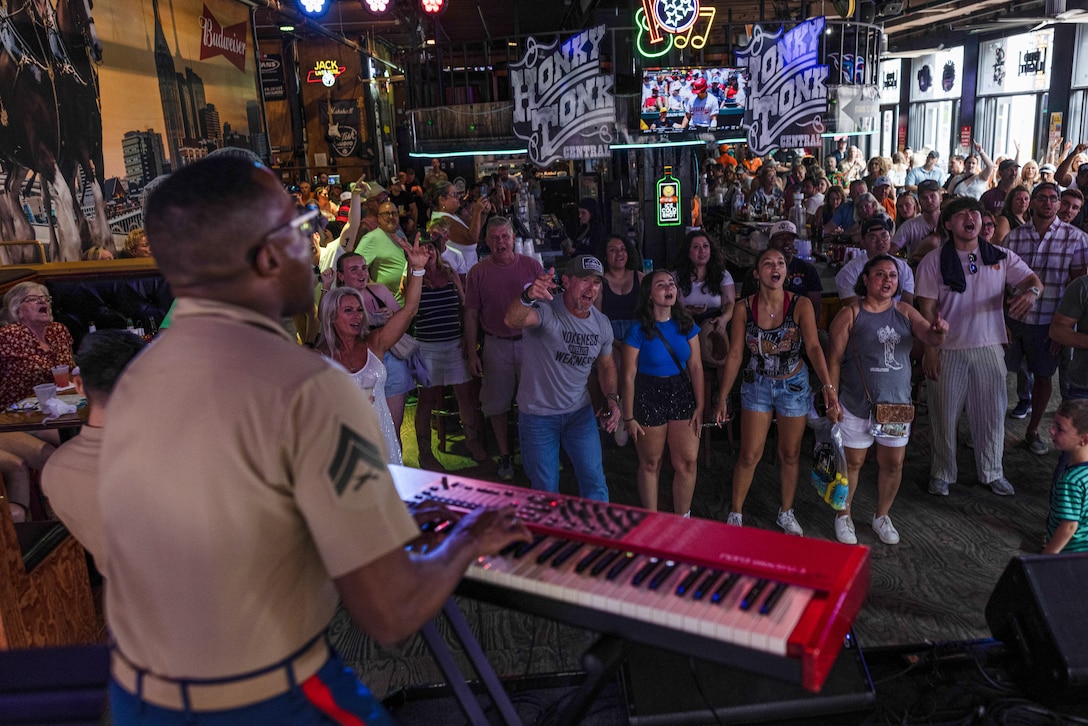 Nashville attendees watch the 2nd Marine Aircraft Wing band, Special-Purpose Marine Air-Ground Task Force 250, perform at the Honky Tonk Central as part of Marine Week Nashville, in Nashville, Tennessee, June 8, 2025. The Honky Tonk Central hosted 2d Marine Aircraft Wing band as a way to show support for the Marine Corps. Throughout 2025, Marines across the globe will celebrate the 250th birthday of the Corps, commemorating service, sacrifice, and priding themselves on living 'Semper Fidelis' or 'Always Faithful' to their nation and to each other. (U.S. Marine Corps photo by Lance Cpl. Judith Ann Lazaro)