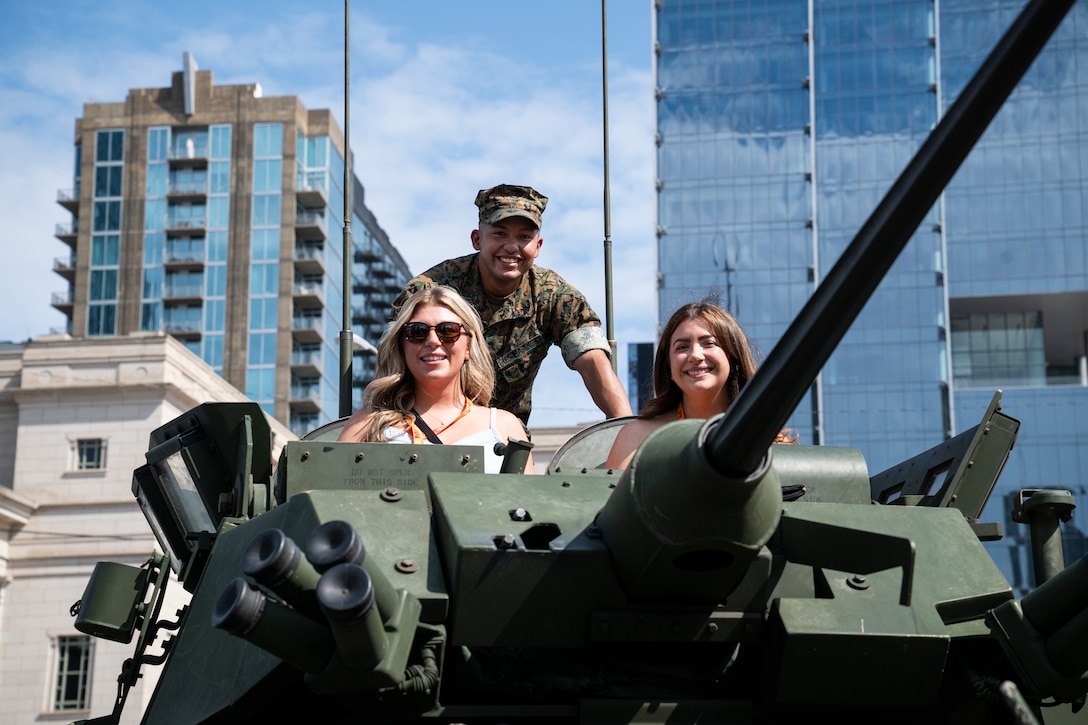 A U.S. Marine with 2d Light Armored Reconnaissance Battalion, Special Purpose Marine Air-Ground Task Force-250, poses for a photo with civilians at a static display during Marine Week Nashville, in Nashville, Tennessee, June 5, 2025. Marines set up multiple equipment displays and recruiting booths during Marine Week to engage with the community of Nashville. Throughout 2025, Marines across the globe will celebrate the 250th birthday of the Corps, commemorating, service, sacrifice, and priding themselves on living ‘Semper Fidelis’ or ‘Always Faithful’ to their nation and to each other. (U.S. Marine Corps photo by Cpl. Vincent Needham)