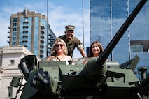 A U.S. Marine with 2d Light Armored Reconnaissance Battalion, Special Purpose Marine Air-Ground Task Force-250, poses for a photo with civilians at a static display during Marine Week Nashville, in Nashville, Tennessee, June 5, 2025. Marines set up multiple equipment displays and recruiting booths during Marine Week to engage with the community of Nashville. Throughout 2025, Marines across the globe will celebrate the 250th birthday of the Corps, commemorating, service, sacrifice, and priding themselves on living ‘Semper Fidelis’ or ‘Always Faithful’ to their nation and to each other. (U.S. Marine Corps photo by Cpl. Vincent Needham)
