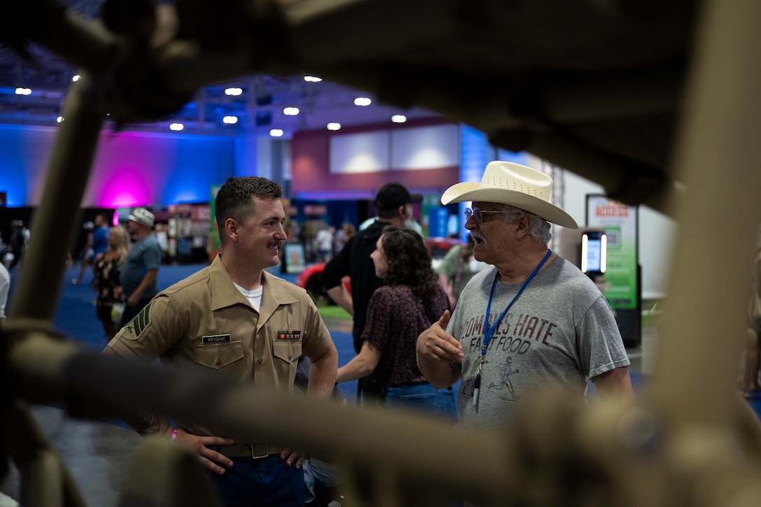 U.S. Marine Corps Sgt. Ethan Krysiak, a recruiter with Recruiting Sub-Station Murfreesboro, Recruiting Station Nashville, speaks to a man in the Music City Center in Nashville, Tennessee, June 5, 2025. Marines set up multiple equipment displays and recruiting booths during Marine Week to engage with the community. Throughout 2025, Marines across the globe will celebrate the 250th birthday of the Corps, commemorating, service, sacrifice, and priding themselves on living ‘Semper Fidelis’ or ‘Always Faithful’ to their nation and to each other. (U.S. Marine Corps photo by Cpl. Vincent Needham)