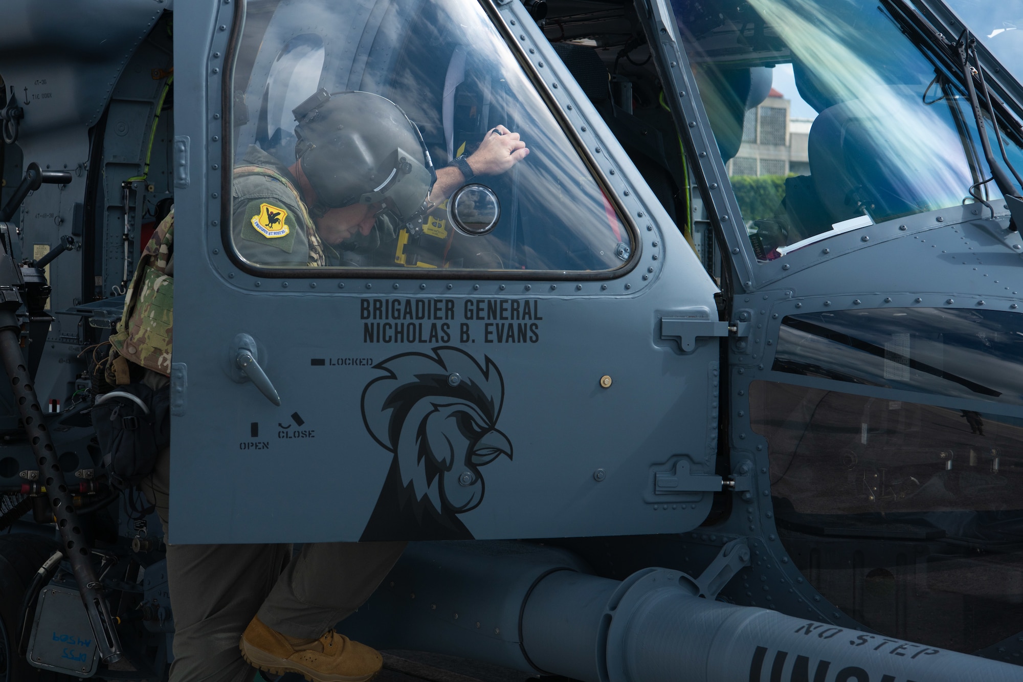 military member climbs into the side door of a helicopter