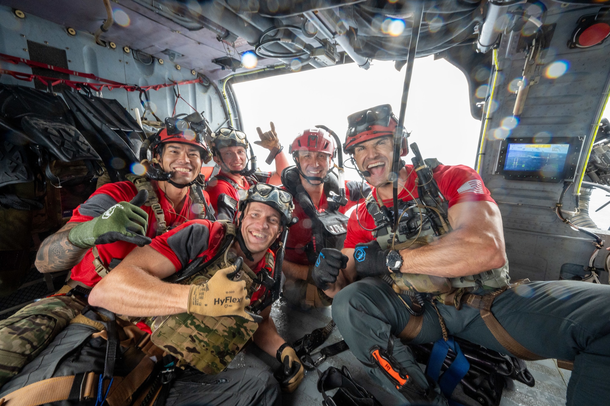 military members group together for a photo inside of a helicopter