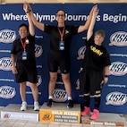 Team Army on the podium at the Olympic Training Center. Chief Warrant Officer 4 Tsuhako (left), Lt. Col. Sanders (middle) and Master Sgt. Pyle-Vandersys (right).