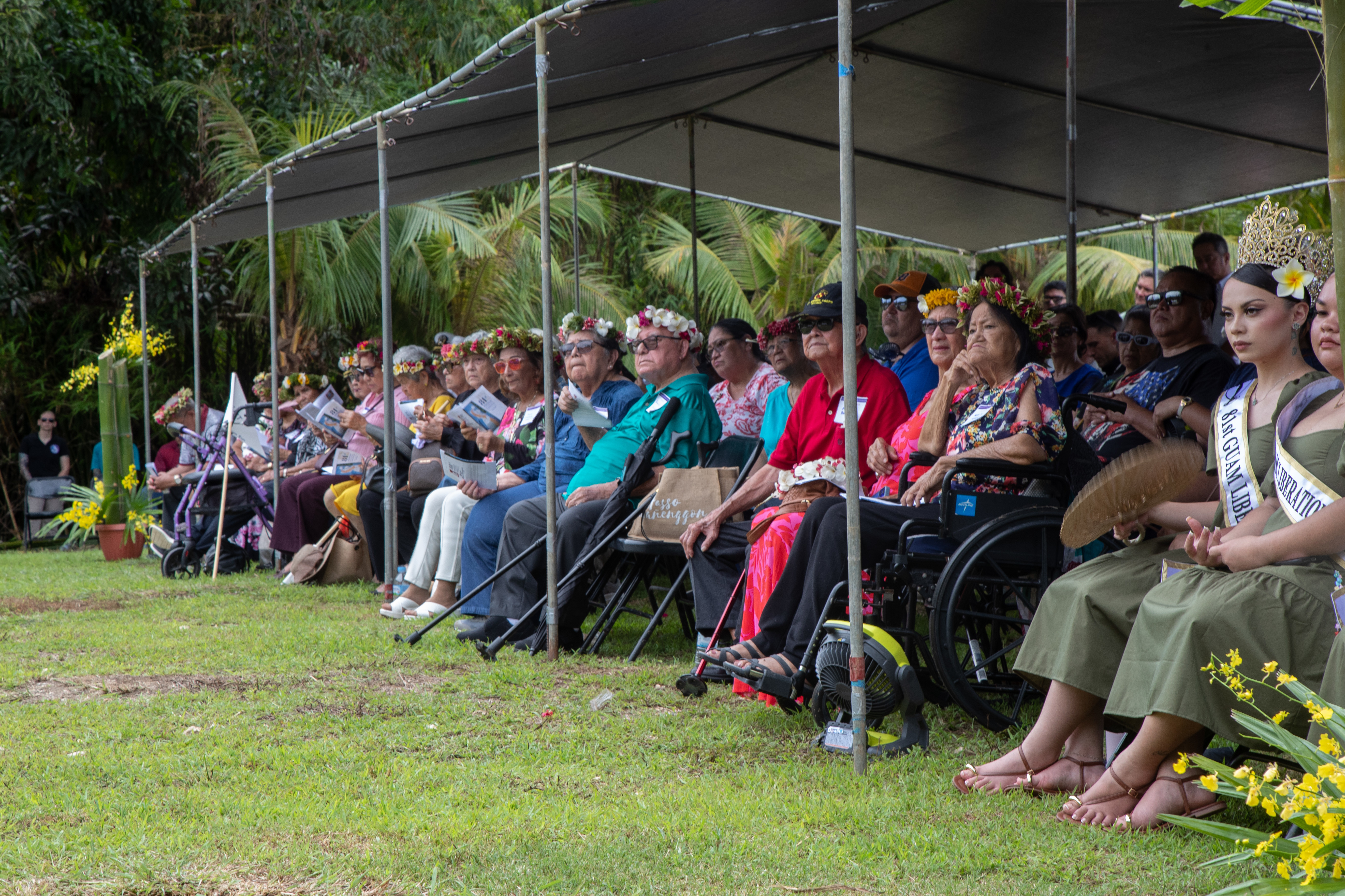 U.S. service members, World War II survivors, Guam residents, and supporters, sit during the Mañenggon Memorial Ceremony as part of the 81st liberation of Guam in Yona, Guam, July 6, 2025. Mañenggon was the site of one of the concentration camps where the Imperial Japanese force-marched and held the CHamoru population during World War II. This memorial service is one of many held across the island to commemorate the liberation of Guam during World War II. (U.S. Marine Corps photo by Lance Cpl. Tanner Currin)