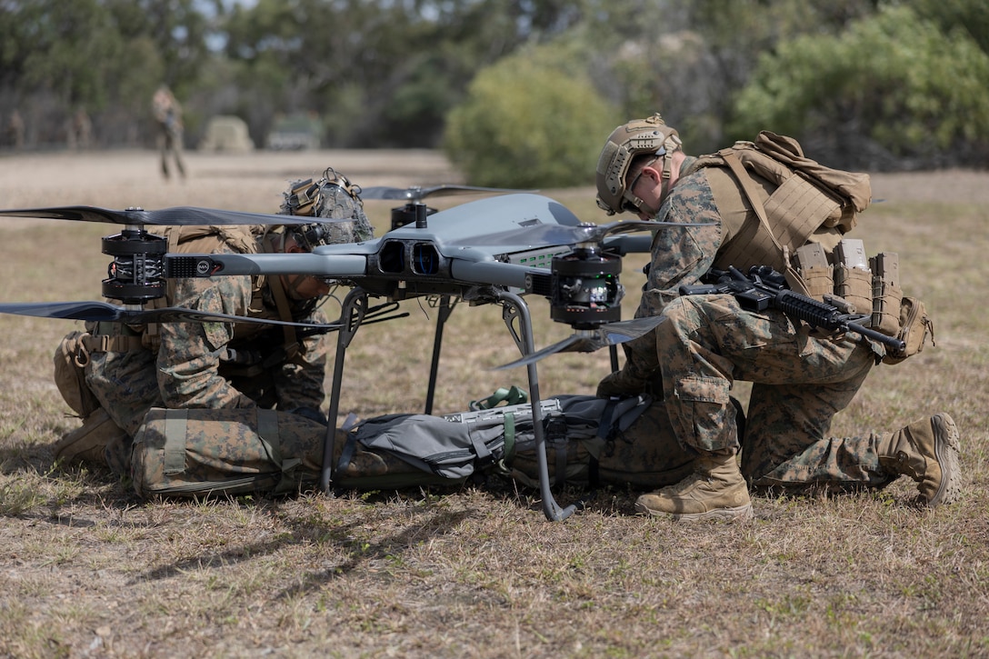 U.S. Marines with Combat Logistics Company-Bravo, Combat Logistics Battalion 31, 31st Marine Expeditionary Unit, retrieve resupply equipment from a Tactical Resupply Unmanned Aircraft System during a resupply exercise, at Sam Hill Airfield, Queensland, Australia, July 5, 2025. The TRUAS is a class 3 unmanned aerial vehicle that can deliver supplies to remote and inaccessible areas. The 31st MEU is operating aboard ships of the USS America Amphibious Ready Group in the 7th Fleet area of operations, the U.S. Navy’s largest forward-deployed numbered fleet, and routinely interacts and operates with allies and partners in preserving a free and open Indo-Pacific region. (U.S. Marine Corps photo by Lance Cpl. Skilah Sanchez)