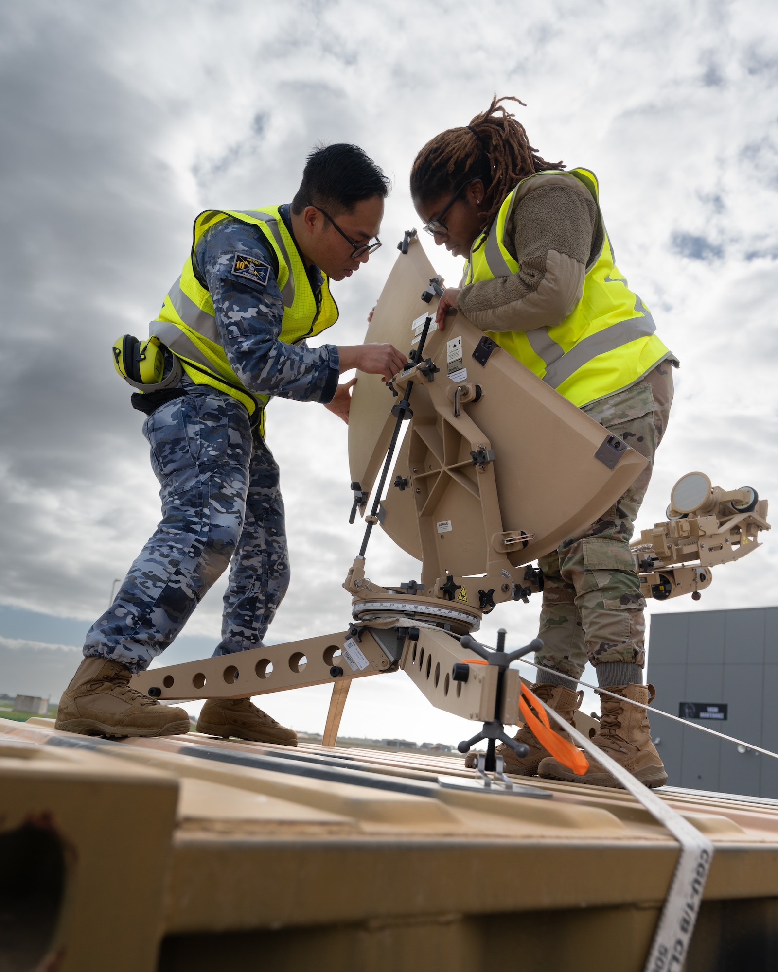 RAAF and U.S. Airmen setup a satellite dish.