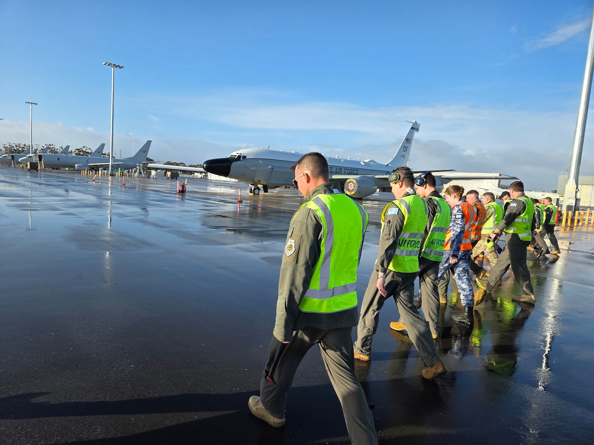 U.S. Air Force and RAAF Airmen walk the flight line to check for debris at Edinburgh.