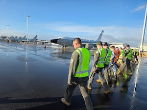 U.S. Air Force and RAAF Airmen walk the flight line to check for debris at Edinburgh.