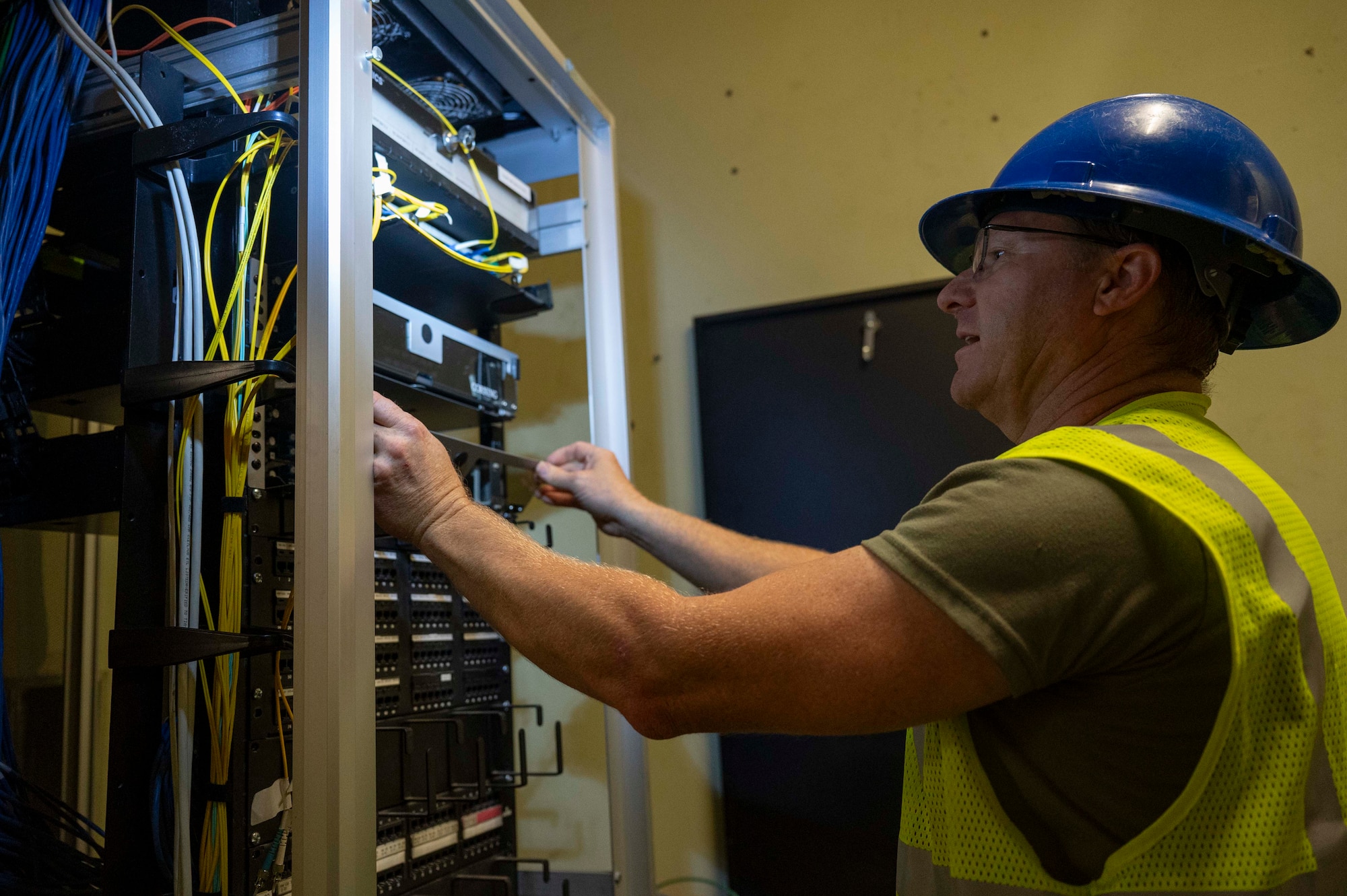 U.S. Air Force Staff Sgt. Johnathan Day, 205th Engineering Installation Squadron cable technician, installs a fiber optic rack-mount connector into a network cable enclosure on Joint Base Pearl Harbor-Hickam, Hawaii, July 9, 2025. The Fiber Deep project underway at Joint Base Pearl Harbor-Hickam, a transformation spearheaded by an U.S. Air National Guard engineering installation team, is set to save approximately $10 million dollars, while simultaneously fortifying against cyber threats. (U.S. Air Force photo by Senior Airman Melody Bordeaux)