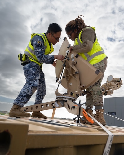RAAF and U.S. Airmen setup a satellite dish.