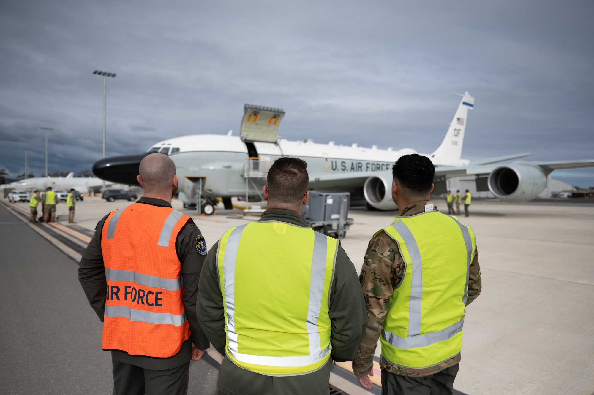 Two U.S. and an RAAF aircrew members observe an RC-135V/W Rivet Joint.