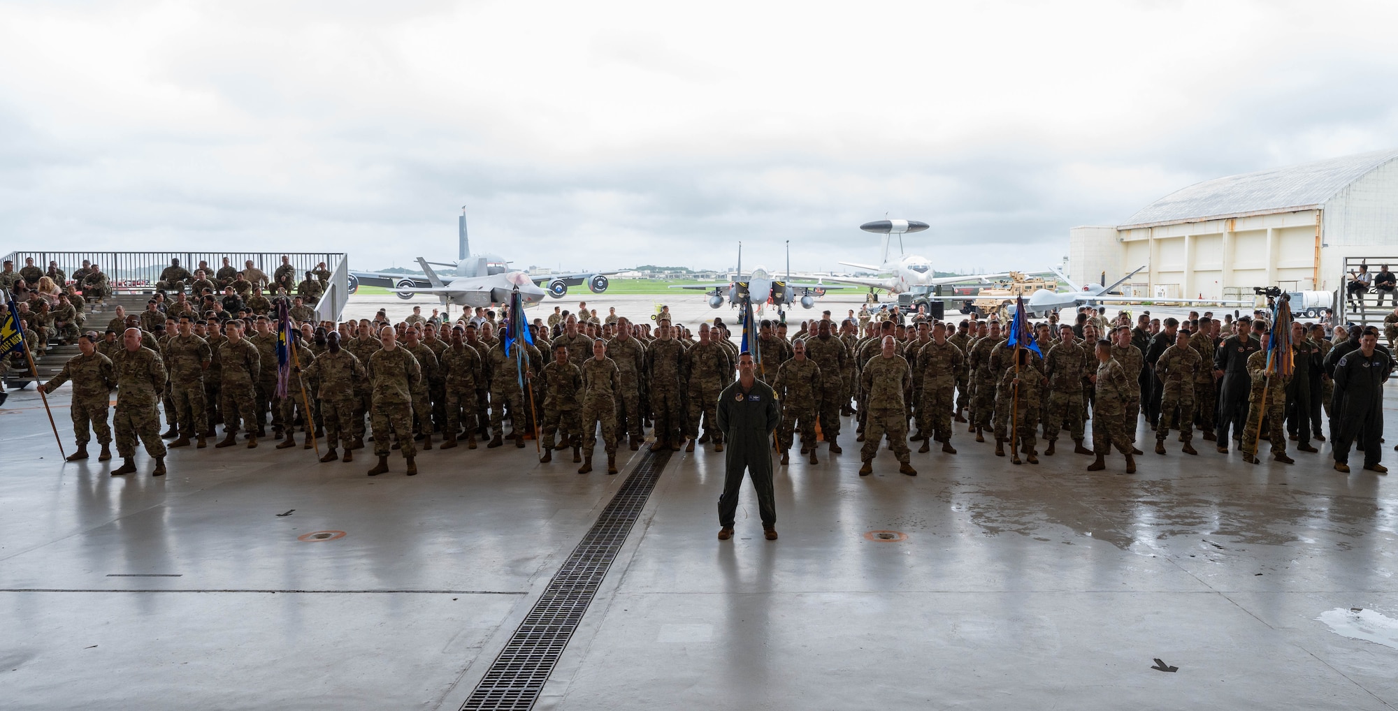Service members stand at parade rest.