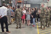 The commander of the 405th Army Field Support Brigade, Col. Ernest Lane II (center left with back to camera), briefs a group of Congressional staff delegates and distinguished visitors at the Powidz Army Prepositioned Stocks-2 worksite in Powidz, Poland, July 3, 2025. (U.S. Army courtesy photo)