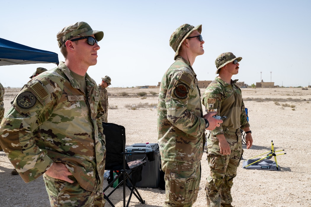 From the left, U.S. Air Force cadets Jacob Marcbach, and Samuel Quick, both U.S. Air Force Academy summer research members, and 1st Lt. Joshua Sheldon, Task Force 99 project arc engineer, watch a drone during training within the U.S. Central Command area of responsibility, June 6, 2025. During their six-week research rotation, cadets collaborate with AFCENT engineers to gain hands-on experience with innovative technologies and strengthen their understanding of operational concepts. (U.S. Air Force photo by Senior Airman Amanda Jett)