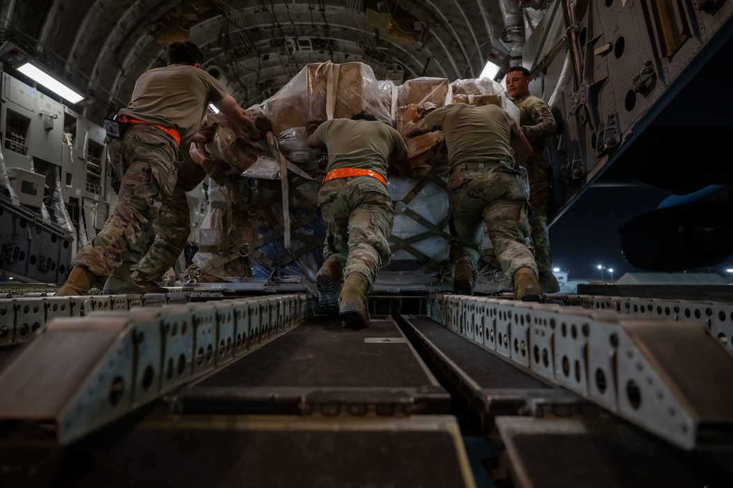 U.S. Airmen assigned to the 379th Expeditionary Air Base Group, upload cargo onto a C-17 Globemaster III within the U.S. Central Command area of responsibility, June 15, 2025. The 379th EABG serves as a key component of the 379th Air Expeditionary Wing, supporting missions ranging from humanitarian airlift and mission-essential combat power to aeromedical evacuation and intelligence operations across multiple theaters. (U.S. Air Force photo by Senior Airman Amanda Jett)