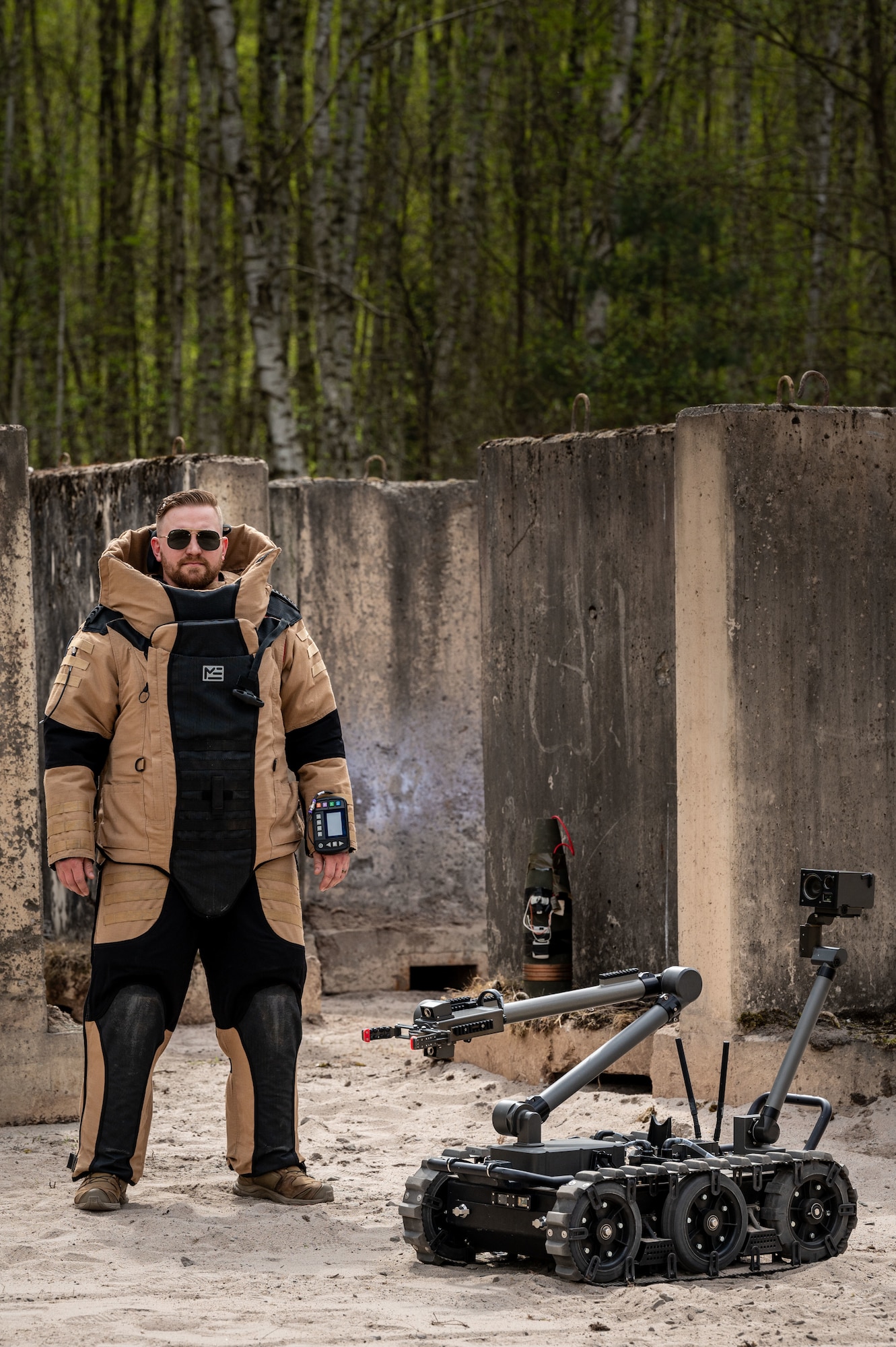 Technical Sgt. Weston Cobb, explosive ordnance disposal technician assigned to the 786th Civil Engineer Squadron, poses in a bomb suit with an EOD robot