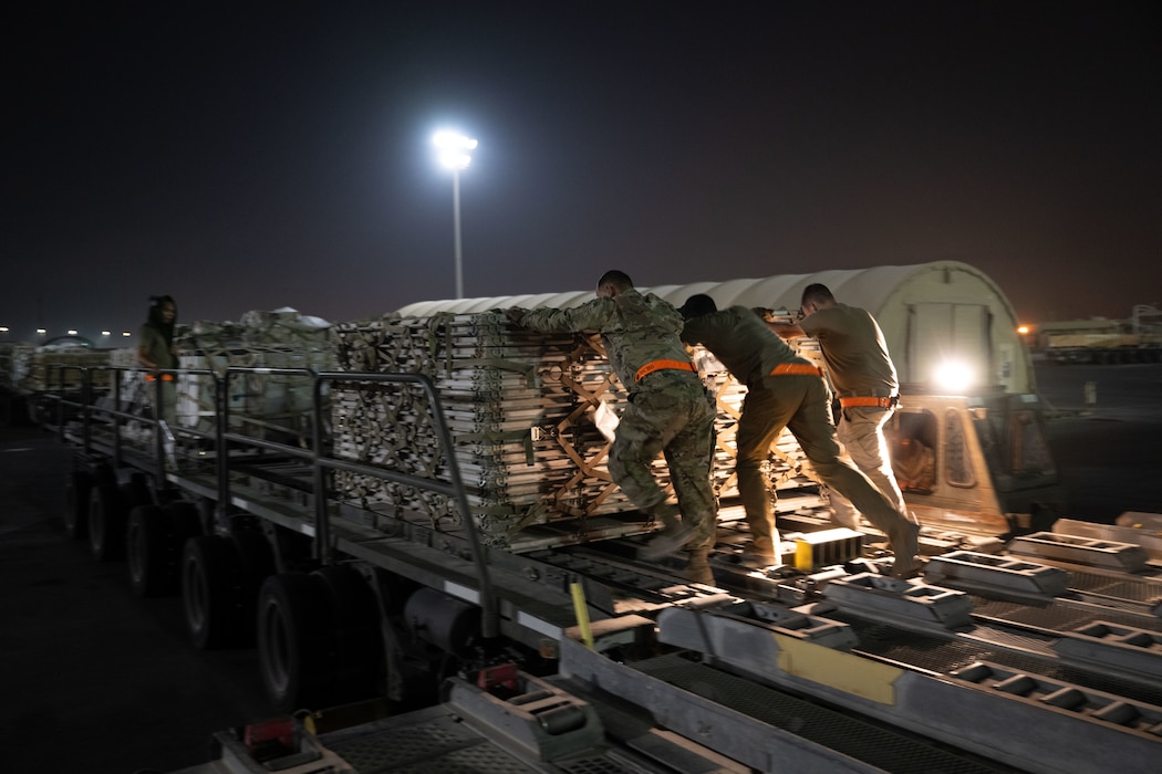 U.S. Airmen assigned to the 379th Expeditionary Air Base Group, load cargo onto a K-loader within the U.S. Central Command area of responsibility, June 15, 2025. Loading crews execute rapid resource deployments to enhance resiliency and sustain combat operations in dynamic environments. (U.S. Air Force photo by Senior Airman Amanda Jett)