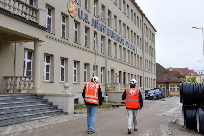 two people walking past building
