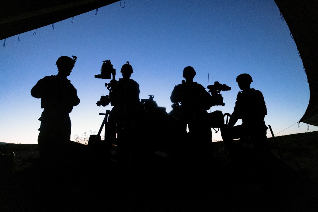 U.S. Marines with B Battery, 1st Battalion, 10th Marine Regiment, 2d Marine Division pose for a group photo on an M777 Howitzer during Service Level Training Exercise 4-25 at Marine Corps Air-Ground Combat Center, Twentynine Palms, California, July 11, 2025. SLTE 4-25 is designed to be a challenging, realistic training environment that produces combat-ready forces capable of operating as an integrated Marine Air Ground Task Force. (U.S. Marine Corps photo by Lance Cpl. Judith Ann Lazaro)